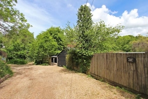 En grusuppfart leder fram till en träbyggnad med en skylt som visar texten ”The Cabin Country Park”.