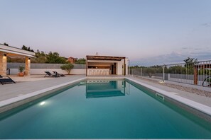 A swimming pool with a patio area, lounge chairs, and a covered seating area. - Villa Casa Olea Zadarvillas (Benkovac)