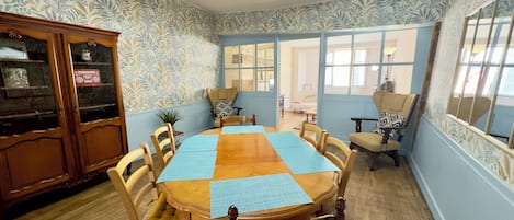A dining room with a wooden table, chairs, and a cabinet.