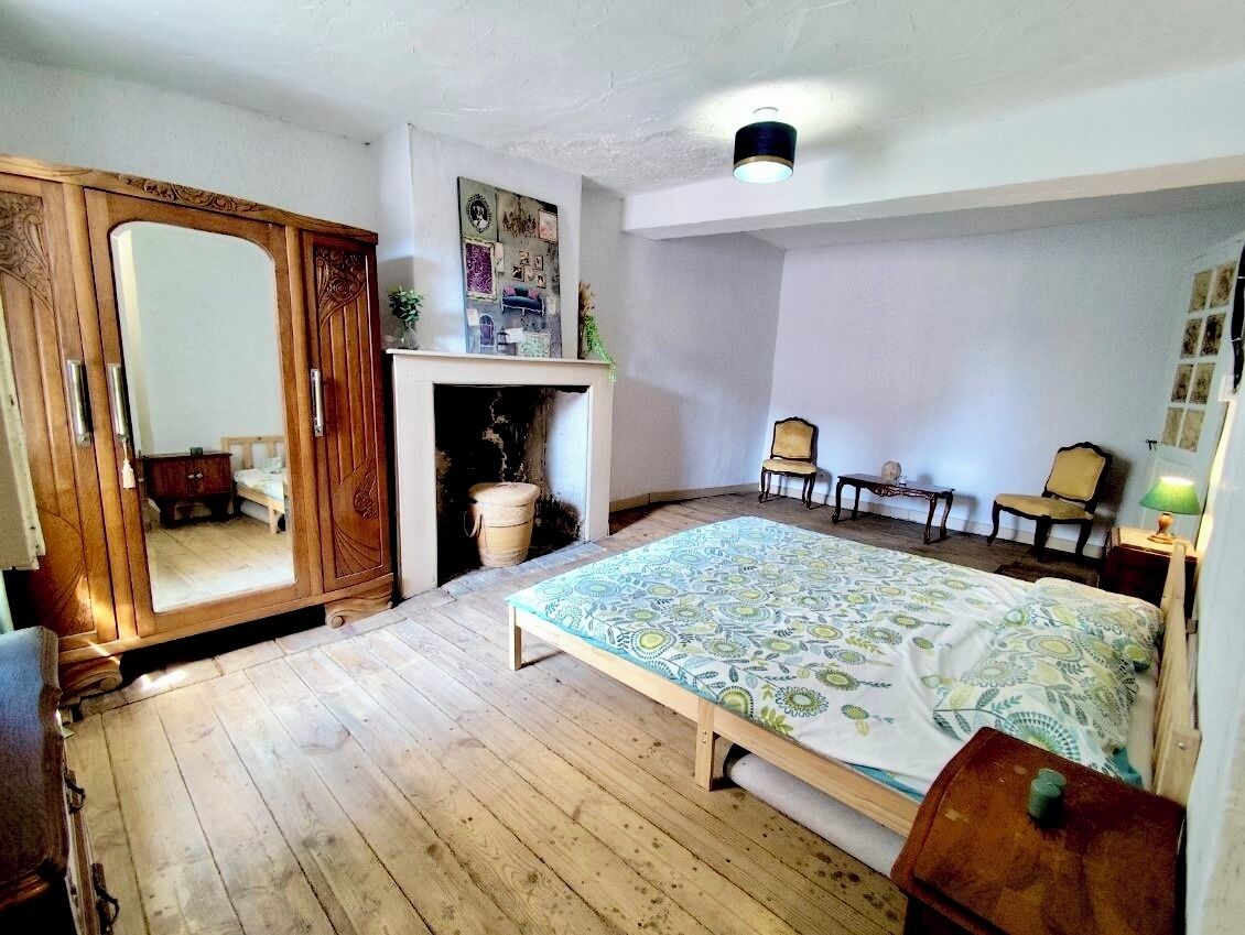 Une chambre à coucher avec un lit, une armoire en bois et une cheminée.