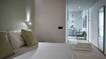 Een moderne hotelkamer met een bed, kussens, een bureau en een stoel.