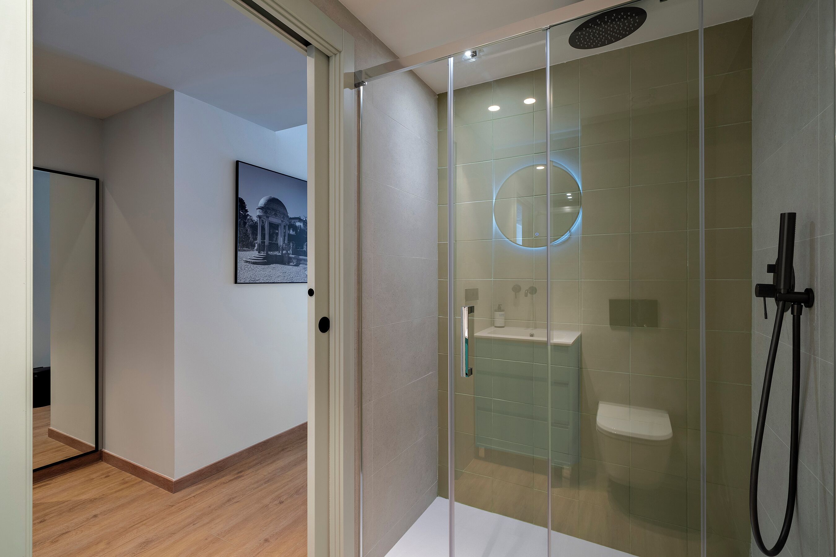 Un baño moderno con ducha de vidrio, inodoro y lavamanos.