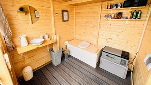 A wooden cabin bathroom with a sink, toilet, and shower area. - The Most Beautiful Way | To Say | "I Love You" (Wadersloh)