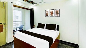 A hotel room with a bed, a ceiling fan, and three framed leaf artworks on the wall. - Townhouse R S Puram Junction (Coimbatore)