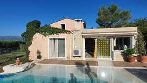 A house with a swimming pool, a covered patio, and a view of the mountains. - A tropical getaway in a private villa near the sea and Nice on the French Riviera! (La Gaude)