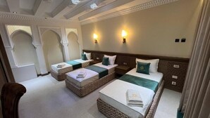 A hotel room with two beds, a sitting area, and a decorative ceiling. - Shams Boutique Hotel (Bukhara)