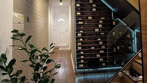 Een modern interieur met een trap, houten vloeren en een muur met een geometrisch patroon.
