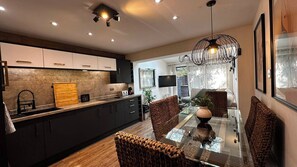 Une cuisine moderne avec des meubles de couleur sombre, un plan de travail en bois et un four encastré.