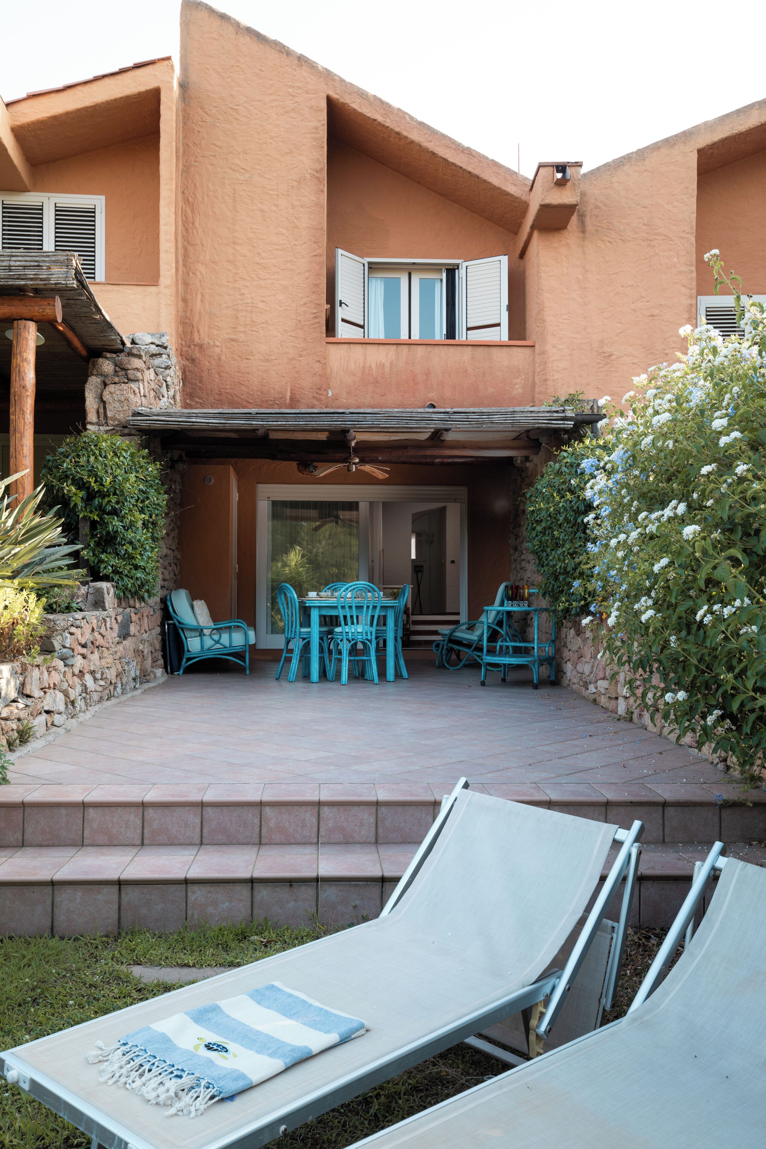 A patio with outdoor furniture, a covered seating area, and a view of the interior.