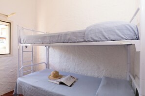 Ein Etagenbett mit einer Zeitschrift und einem Strohhut auf der unteren Koje.