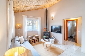 Ein modernes Wohnzimmer mit einer Couch, einem Couchtisch, einem Fernseher und einem Kamin.