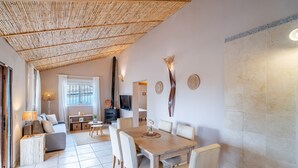 A modern interior with a dining area, sofa, and a television. - Cubo's Casa Alaya & Oasis Pool / Private pool / Air conditioning / BBQ / Free Wi-Fi (Coín)