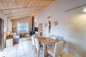 Ein modernes Interieur mit Essbereich, einer Couch und einem Fernseher.