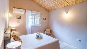 A bedroom with a bed, a chair, a window, and wall-mounted lights. - Cubo's Casa Alaya & Oasis Pool / Private pool / Air conditioning / BBQ / Free Wi-Fi (Coín)