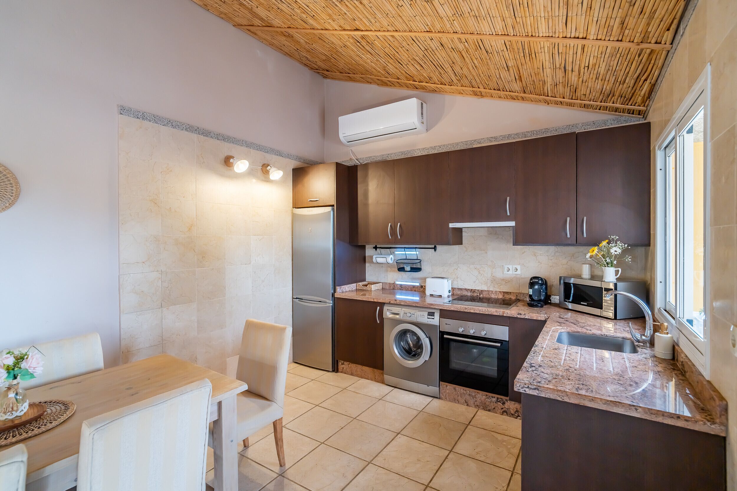 A modern kitchen with a built-in washing machine, a microwave, and a toaster.