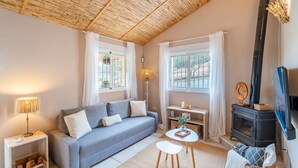 A cozy living room with a sofa, a small table, a lamp, a fireplace, and a television. - Cubo's Casa Alaya & Oasis Pool / Private pool / Air conditioning / BBQ / Free Wi-Fi (Coín)