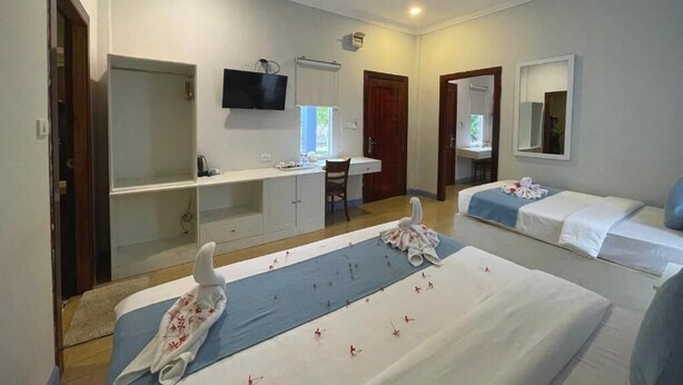 A hotel room with two beds, a desk, a chair, a TV, and a mirror. - Scarlet Sails Resort Koh Rong (Koh Rong)