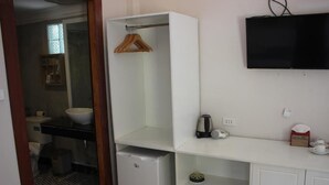 A bathroom with a toilet, sink, and a white cabinet with a hanging rack. - Scarlet Sails Resort Koh Rong (Koh Rong)