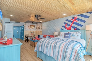 A nautical-themed bedroom with a bed, a desk, and a dining area. - Yachtsman S503B Studio (Myrtle Beach)