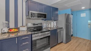 A modern kitchen with stainless steel appliances, a built-in microwave, and a refrigerator. - Yachtsman S503B Studio (Myrtle Beach)