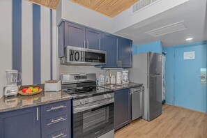 A modern kitchen with stainless steel appliances, a built-in microwave, and a refrigerator. - Yachtsman S503B Studio (Myrtle Beach)