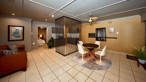 Un intérieur moderne comprenant un coin repas, un canapé et un ventilateur de plafond.