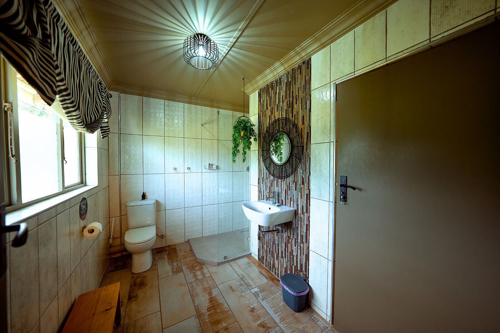 A bathroom with a toilet, sink, and shower area.