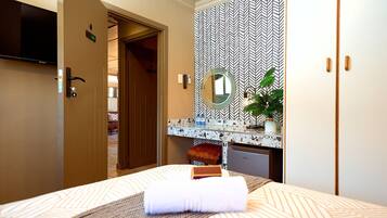 A hotel room with a bed, a bathroom with a mirror, a sink, and a television.