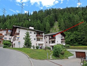 A multi-story building with balconies, surrounded by a forested hillside. - Soras Demarmels Appartement/Fewo, Dusche, WC, 2 Schlafräume by Interhome (Savognin)