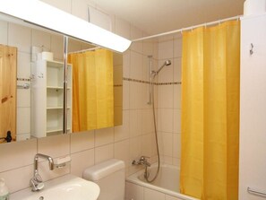 Kylpyhuone, jossa on kylpyamme, wc, pesuallas ja peili.
