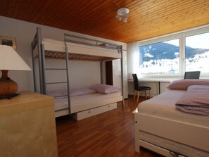 A bedroom with bunk beds, a desk, and a chair. - Tgesa Sunnmatt Nr. 13 Appartement/Fewo, Bad, WC, 1 Schlafraum by Interhome (Savognin)