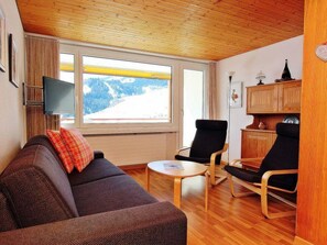 A cozy living room with a sofa, chairs, a small table, and a TV. - Tgesa Sunnmatt Nr. 13 Appartement/Fewo, Bad, WC, 1 Schlafraum by Interhome (Savognin)
