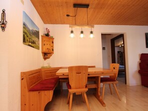 Ein Essbereich aus Holz mit einer Bank, einem Tisch und drei Pendelleuchten.