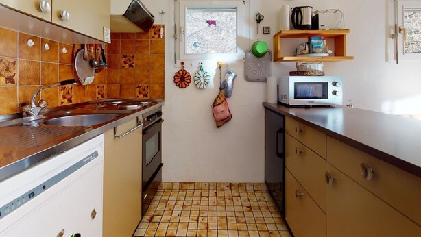 A compact kitchen with a stove, sink, and microwave. - Soras Zerbe/Hirth Appartement/Fewo, Bad, WC, 1 Schlafraum by Interhome (Savognin)
