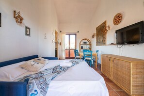 Ein Hotelzimmer mit einem Bett, einem Fernseher, einem Schreibtisch mit Stuhl und einem Kleiderschrank.