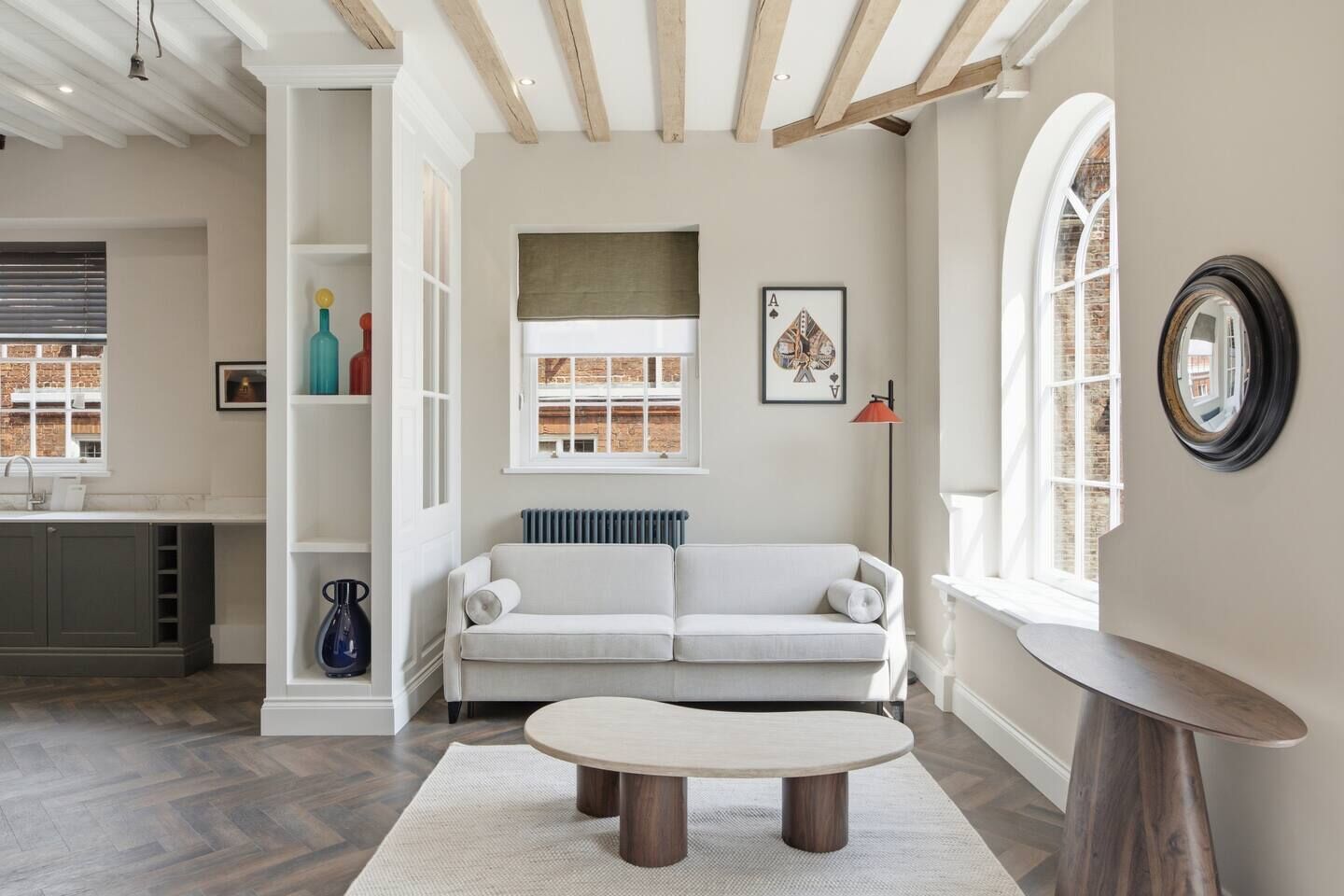 A living room with a sofa, a coffee table, and a view of a brick building through a window.