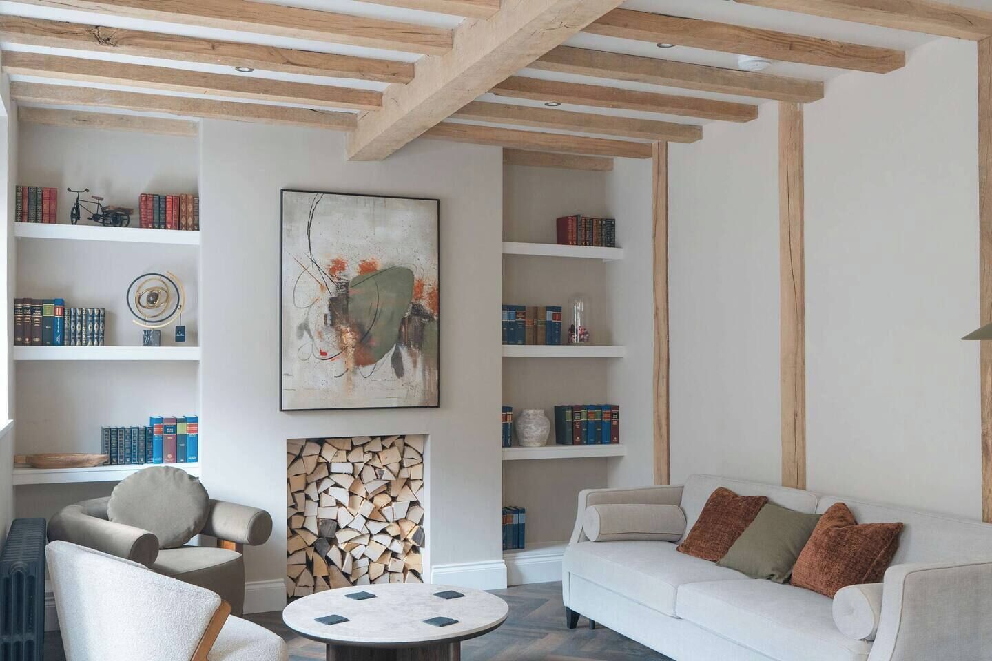 A living room with a white sofa, a round coffee table, and bookshelves filled with books and decorative items.
