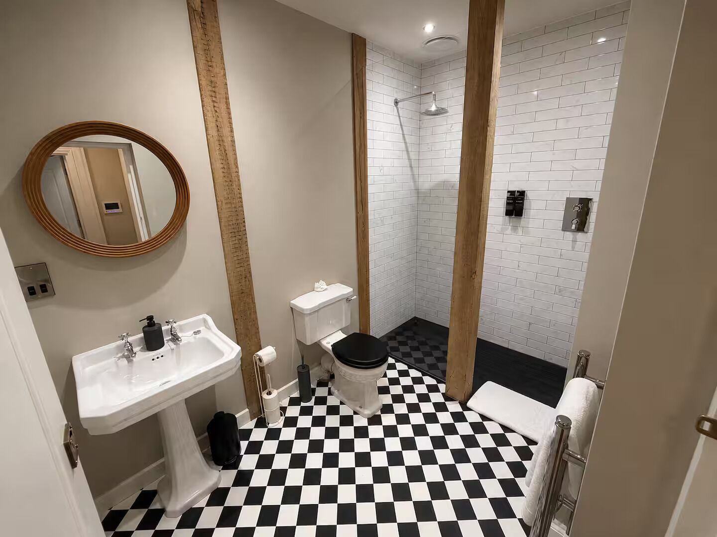 Un baño con piso a cuadros, un lavamanos, un inodoro y una zona de ducha.