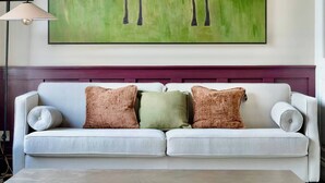 Ein Wohnzimmer mit einer Couch, einem Couchtisch und einem großen abstrakten Gemälde an der Wand.