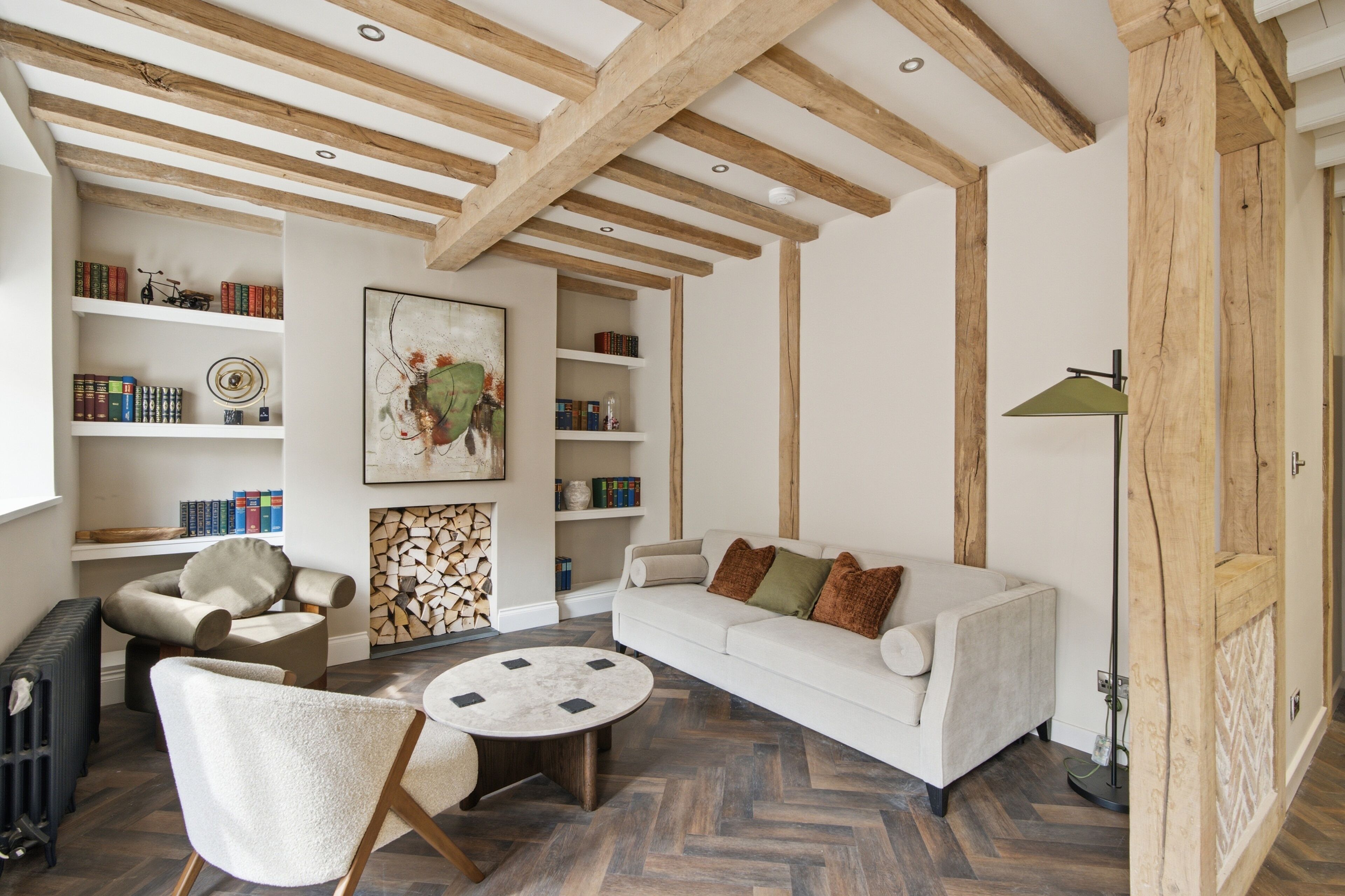 A living room with a white sofa, a round coffee table, and a bookshelf filled with books.
