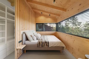 Une chambre à coucher avec un lit, une fenêtre et une armoire intégrée.