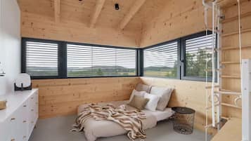 Un dormitorio con cama, mesita de noche, lámpara y ventana con persianas.
