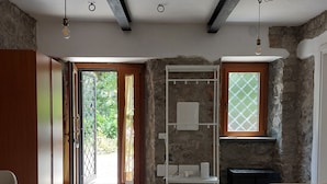 Un salón amplio con un tapete grande, un sofá y una pared de piedra.