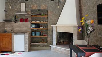 Una cocina moderna con pared de piedra, repisas de madera y horno empotrado.