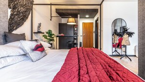 A modern bedroom with a large bed, a red quilt, and a unique wall art piece. - Luxury Suite - Tentazioni Nascoste (Perugia)