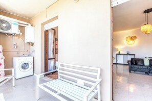 A living area with a white bench, a washing machine, and a ceiling fan. - Luxury Suite - Tentazioni Romantiche (Perugia)