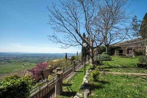 Una escalera de piedra que conduce a una terraza con vistas despejadas al campo.