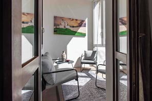 A room with a bed, a chair, a small table, and a painting of a landscape. - Casetta Stella (Assisi)