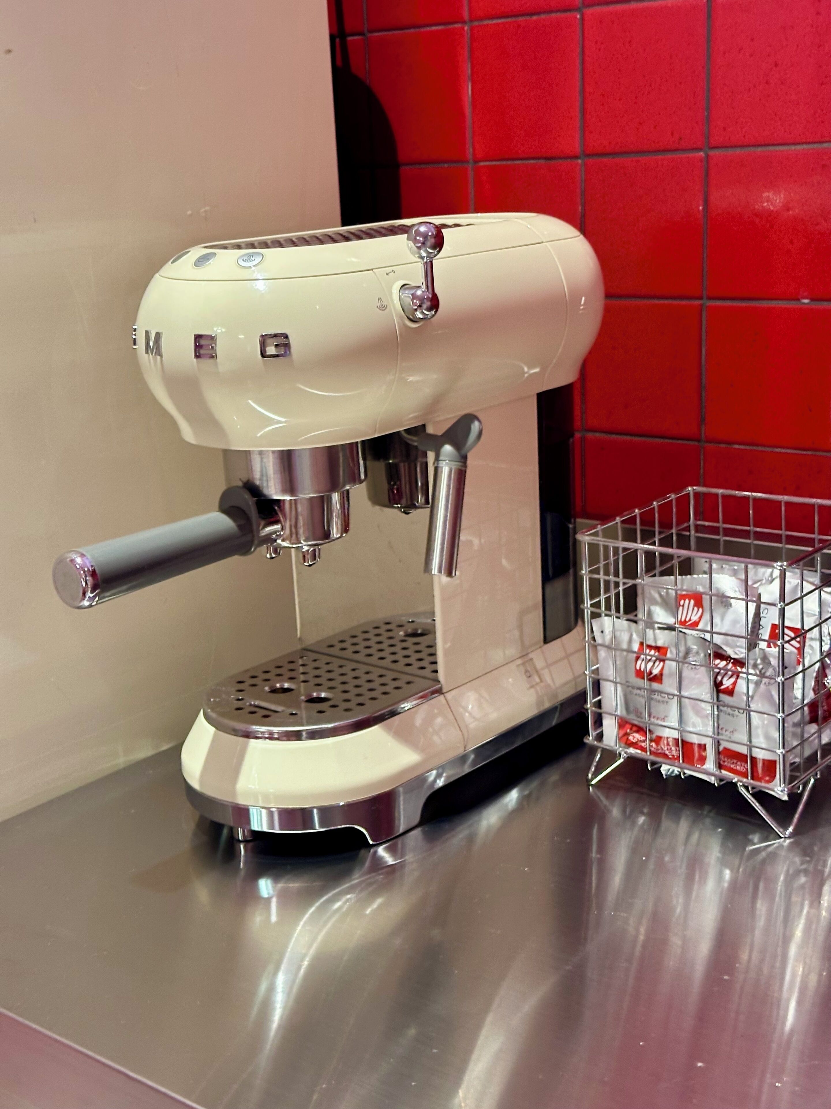 A coffee machine with a metal basket containing coffee pods.