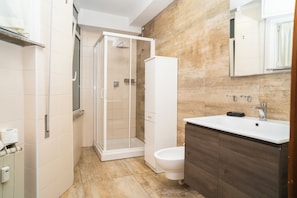 Un baño moderno con ducha, inodoro y lavamanos.